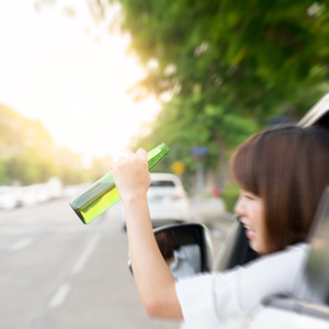 a woman holding a beer outside the driver side window of a car