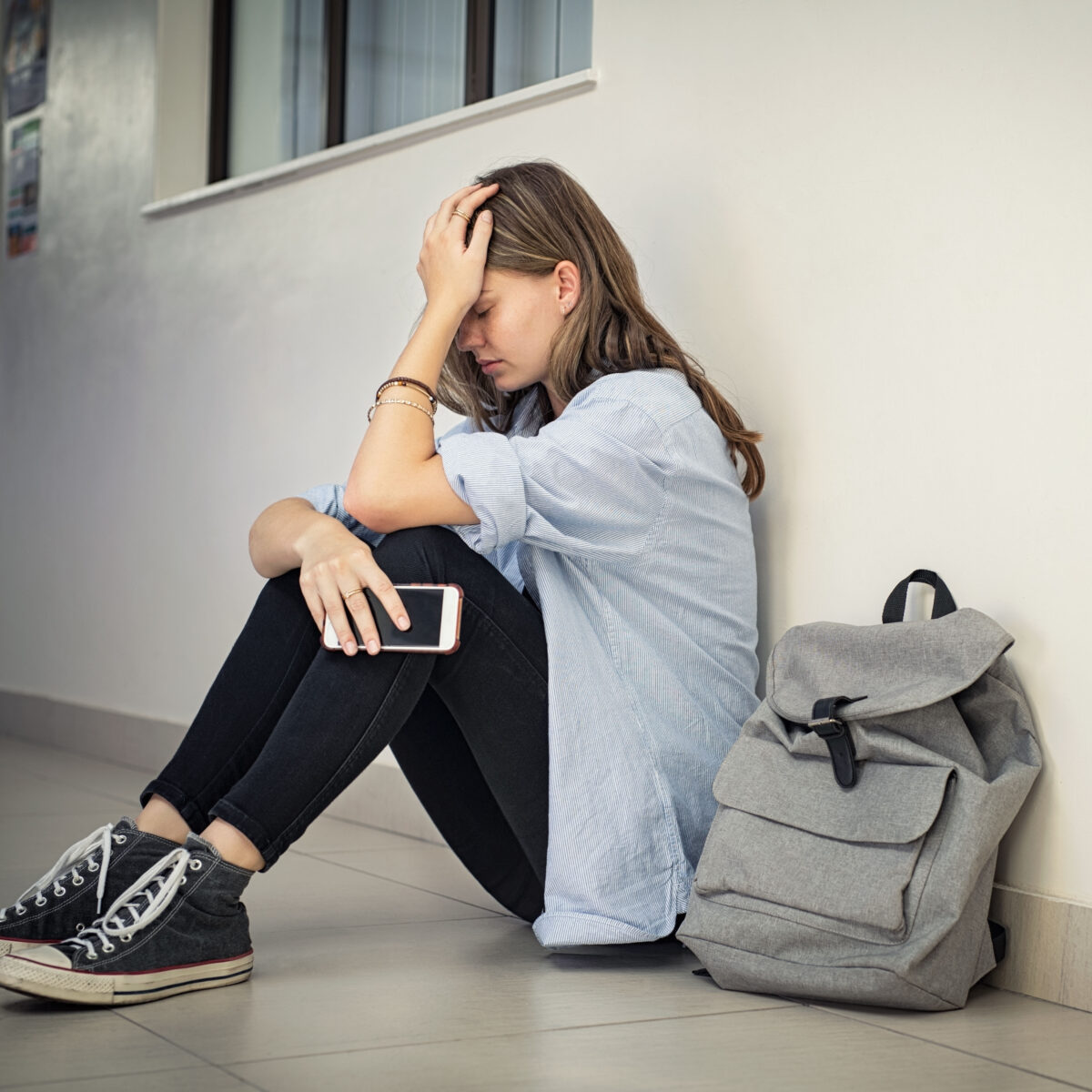 a teenage girl holding her head in her hands