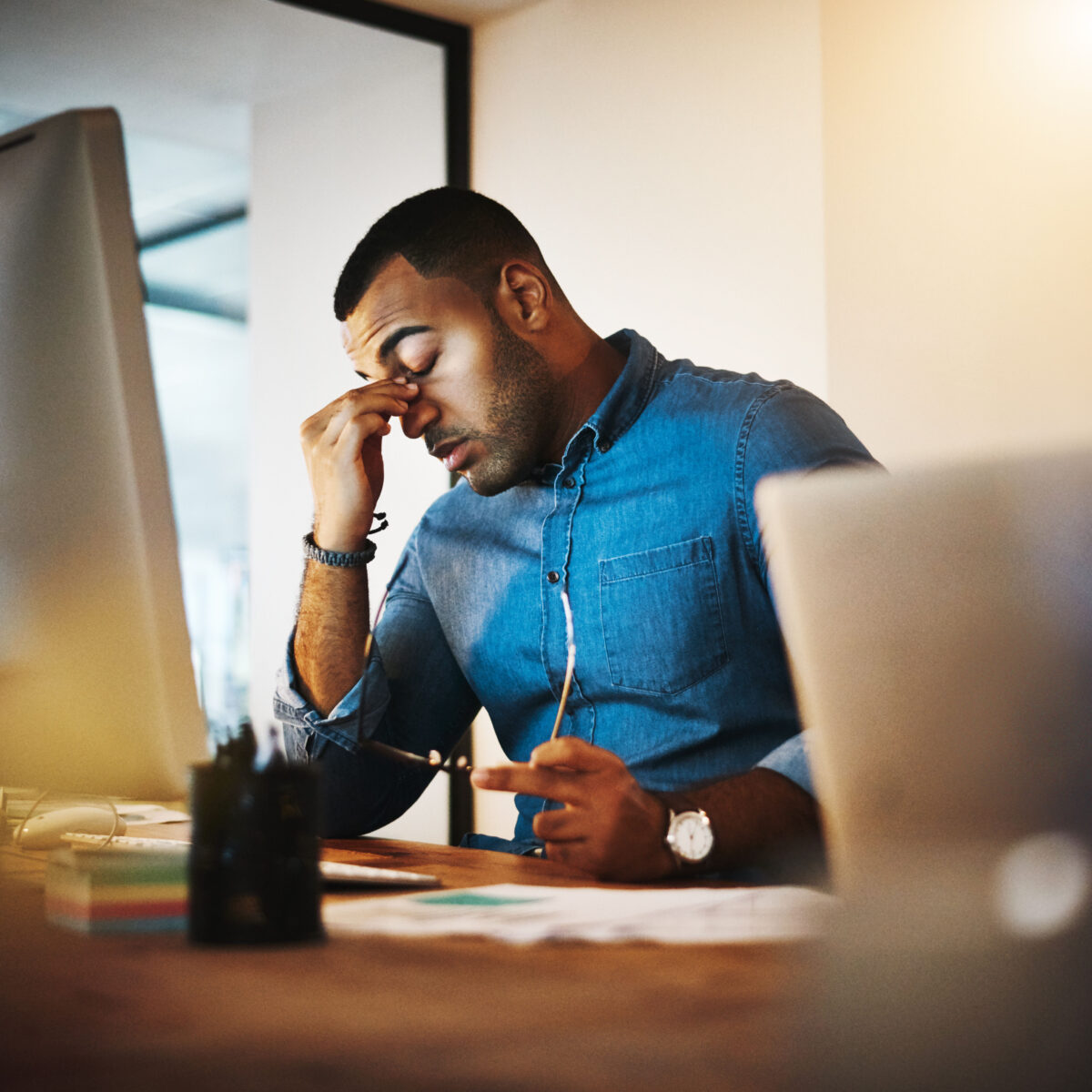 a man holding his head in shame in front of his computer